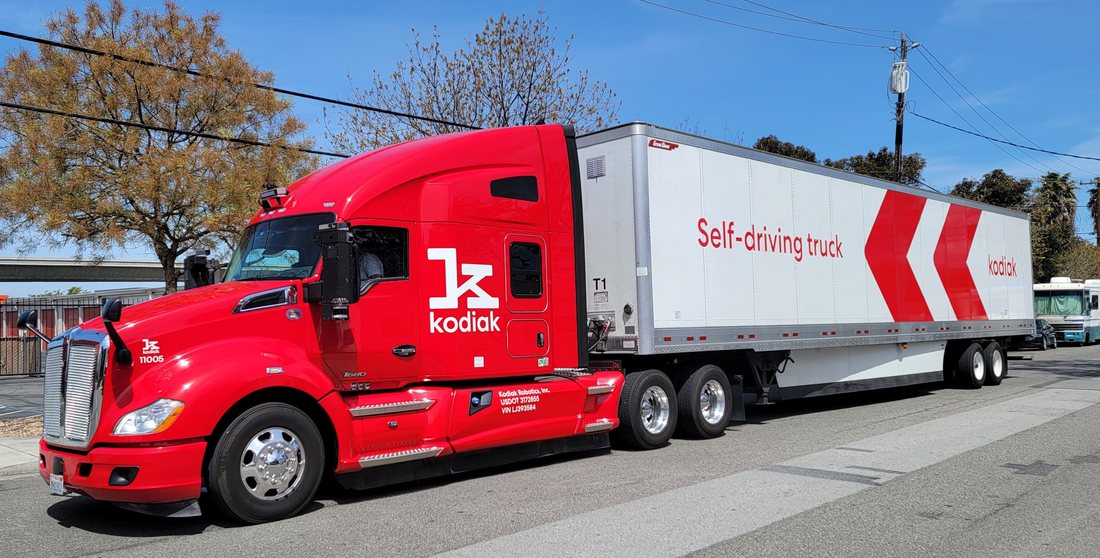 Un semi-remorque rouge de Kodiak Robotics, avec la mention Self-driving truck peinte sur la remorque