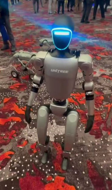 Le robot humanoïde Unitree G1, bipède, marchant au milieu d'une foule